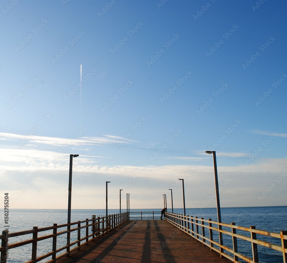 Fototapeta premium Lonely pier stretching into the sea under clear sky