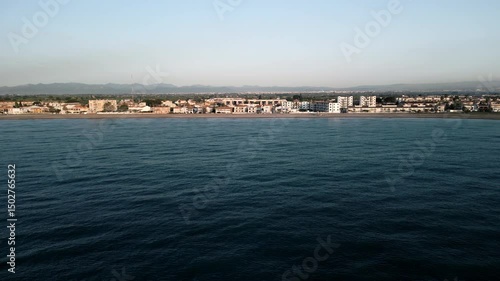 Wallpaper Mural Drone flight over the city embankment along the sea and the beach.
with a view of the Town, sunrise lighting parallel to the beach flight Torontodigital.ca