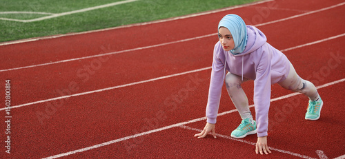 Sporty Muslim woman getting ready to run at stadium