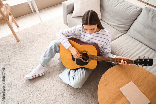Young woman playing acousti...