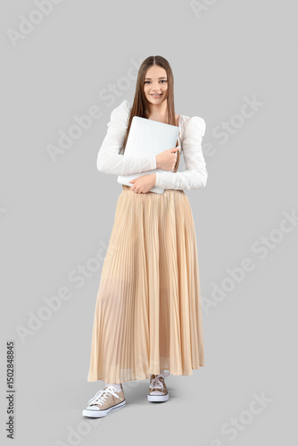 Young woman with laptop on ...