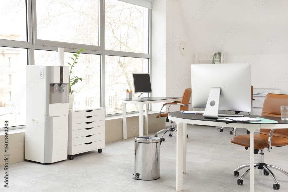 Fototapeta premium Interior of light office with water cooler and desks