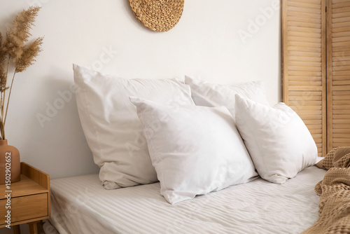 Soft white pillows on bed i...