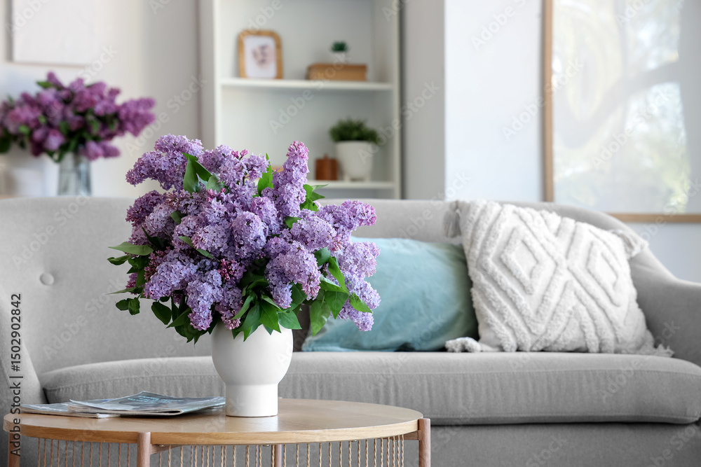 Obraz premium Vase with beautiful lilac flowers and magazines on table in living room
