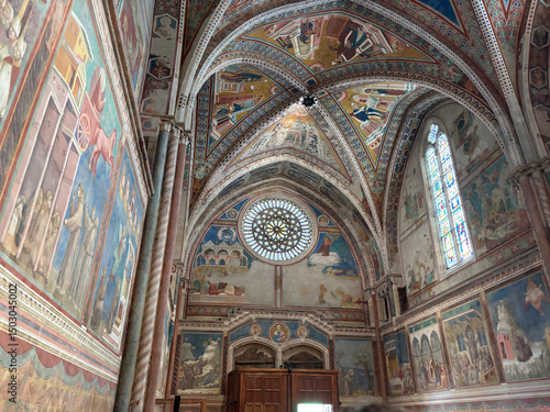Interior of the Basilica of Saint Francis of Assisi with colorful frescoes by Giotto on the walls and ceiling. Italy.