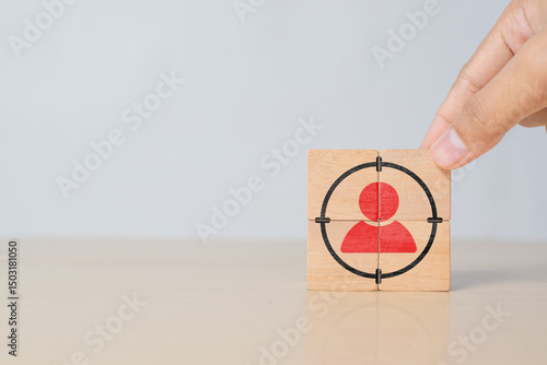 Hand putting wooden cubes with focused on target customer symbols. Target customer, buyer persona, marketing segmentation, job recruitment concept. 