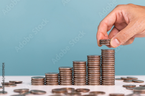 Concept for investment, Invest, profit, finance and saving money. A man put down coins stack step growing growth indicates saving money