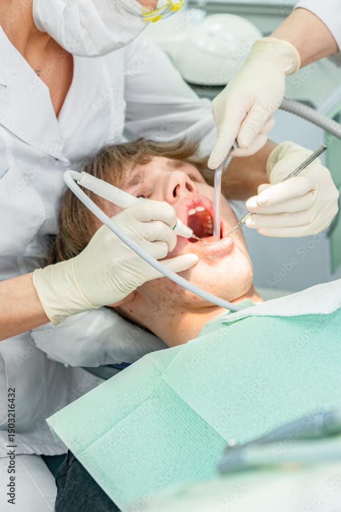 Obraz premium Teenager undergoes dental procedures in a bright clinic with professionals attending to oral health needs