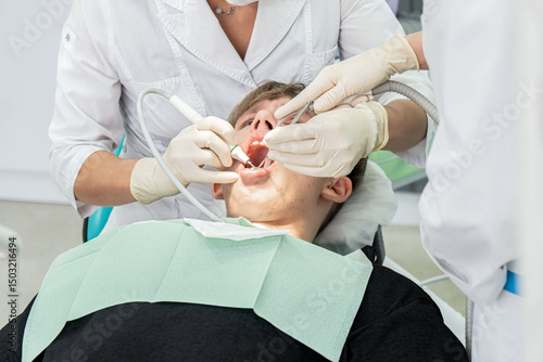 Teenager undergoes dental procedures in a bright clinic with professionals attending to oral health needs