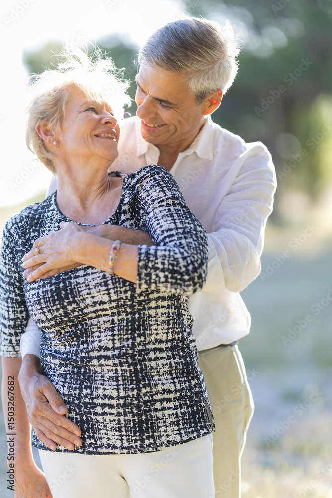 Naklejka premium Happy senior couple embracing in summer park