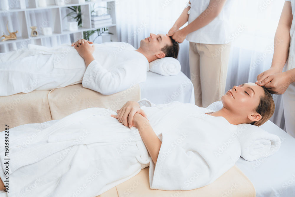 Obraz premium Caucasian couple enjoying relaxing anti-stress head massage and pampering facial beauty skin recreation leisure in dayspa modern light ambient at luxury resort or hotel spa salon. Quiescent