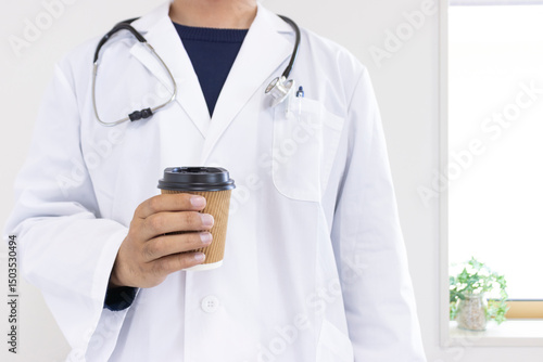 紙コップのコーヒーを持つ医者のイメージ（日本人、男性、顔無し、30代）