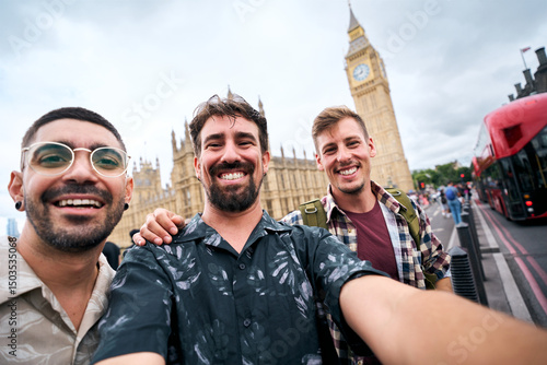 Photography Three happy male tourists are posing for a selfie in london with the houses of p