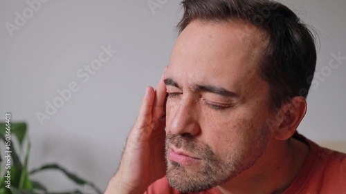 Close up Man touching temple, forehead and head due to headache and feeling unwell
