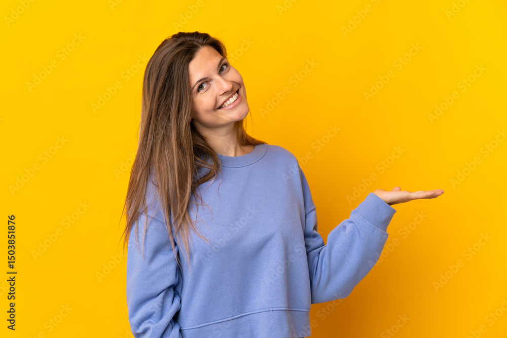 Young Slovak woman isolated on yellow background extending hands to the side for inviting to come Young Slovak woman isolated on yellow background extending hands to the side for inviting to come
