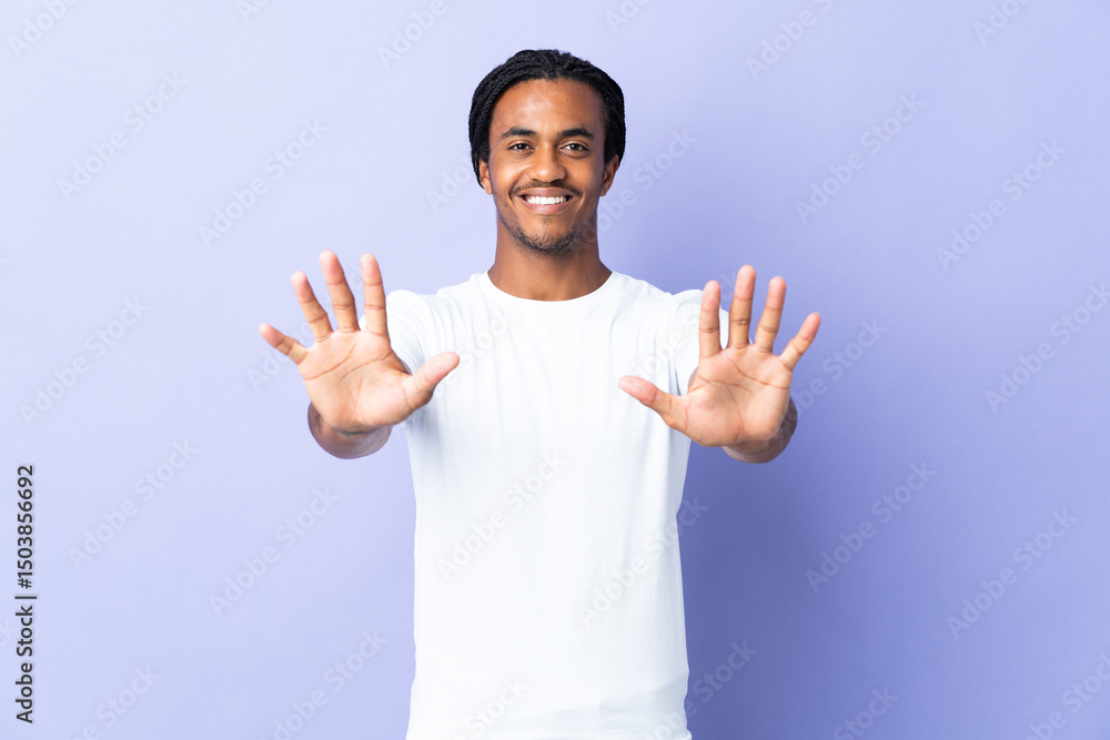Fototapeta premium Young African American man with braids man isolated on purple background counting ten with fingers