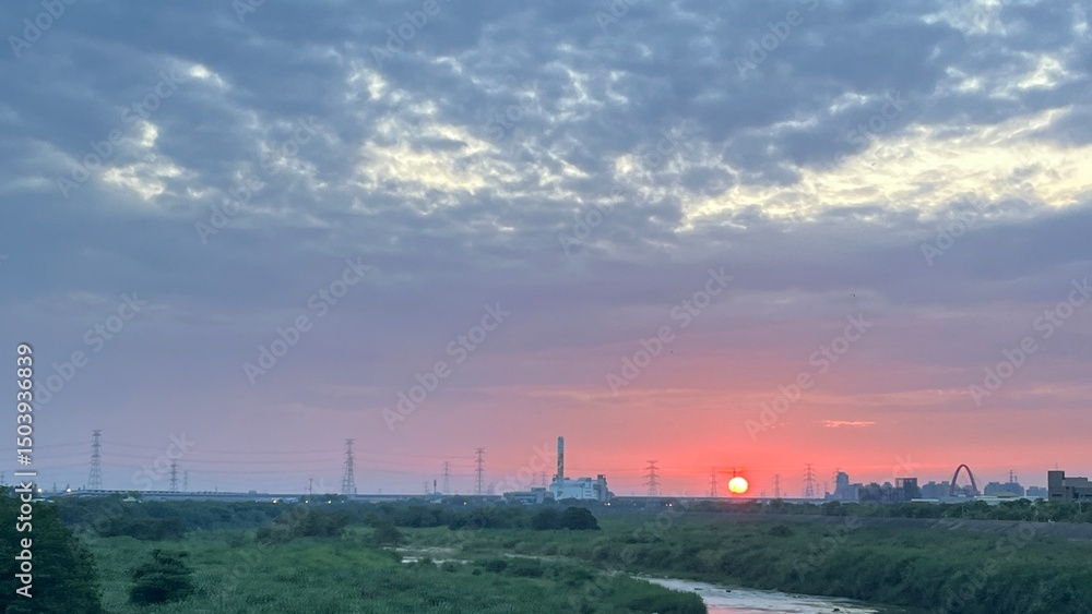 City sunset with river, power lines, and dramatic sky City sunset with river, power lines, and dramatic sky