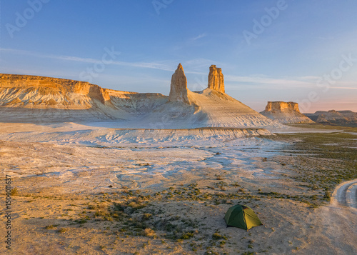 The rock peaks with sunset light with a camping tent in Boszhira on the Ustyurt Plateau in Mangystau, Kazakhstan