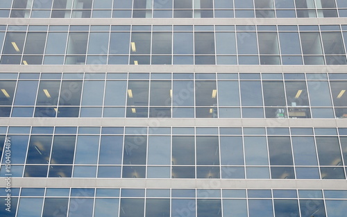 Generic office building exterior with sky reflected in glass windows