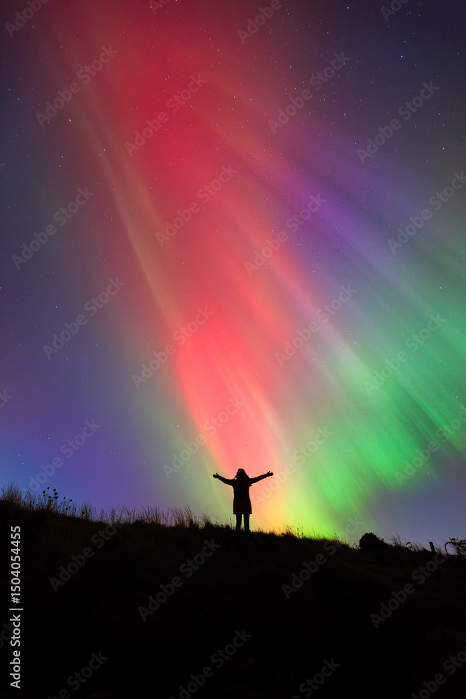 Fototapeta premium Woman Silhouette with Northern Lights, Ireland – Colorful Aurora Borealis Sky