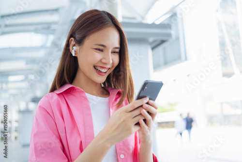 Free Download Beautiful young Asian woman using smartphone in public areas, During leisure time. The concept of using the phone is essential in everyday life. - GFXLoad