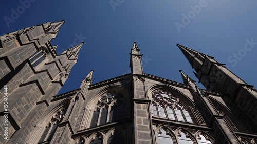 Gothic cathedral with towering spires and ornate stone architecture under clear sky

