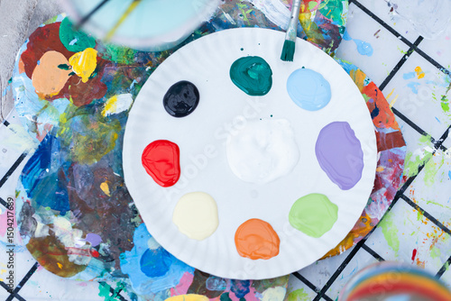 Wallpaper Mural Sustainable and ecofriendly craft setup with painting palette featuring various paint colors on paper plate surrounded by artistic tools and creative art materials Torontodigital.ca