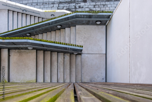 Contemporary architectural facade with linear elements and green rooftop, minimalist geometry and rhythm for architecture, design and urban development themes.