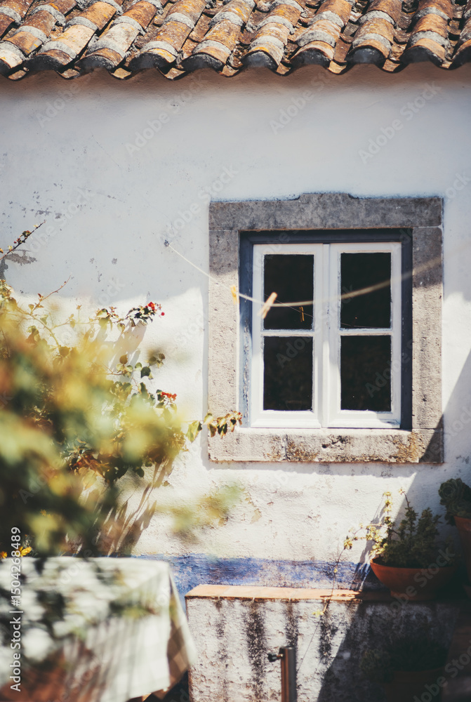custom made wallpaper toronto digitalRustic whitewashed wall with a small wooden window framed in stone, beneath a sunlit terracotta tile roof, surrounded by climbing plants and a cozy outdoor seating corner