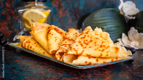 Pila de crepes caseras frescas con limón sobre fondo rústico