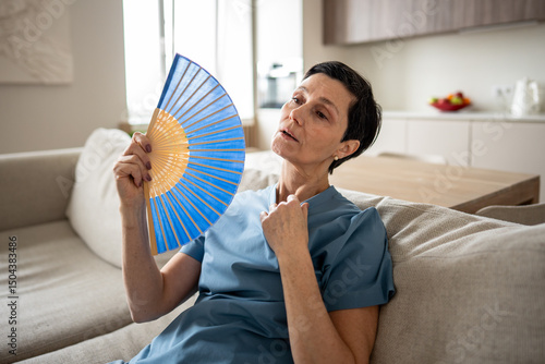 Картината върху платно Weary tired stressed woman fanning at home, sweating profusely
