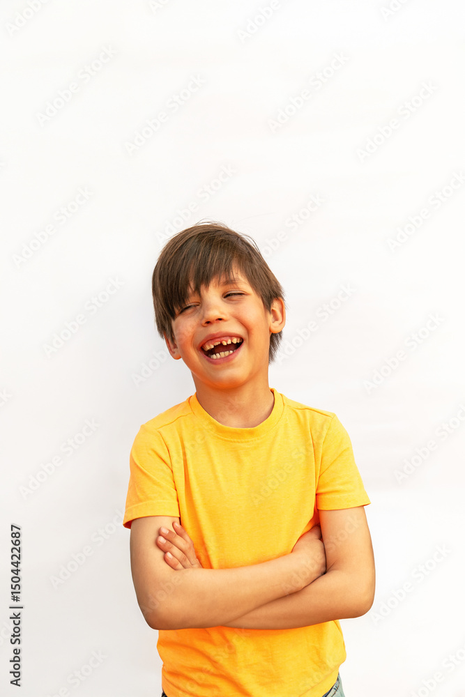 Cheerful boy crossed his arms laughing on white background. Vertical photo Cheerful boy crossed his arms laughing on white background. Vertical photo