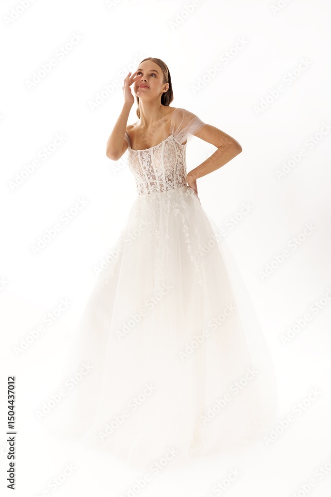 Elegant bride in a flowing white gown poses gracefully against a simple background during a portrait session Elegant bride in a flowing white gown poses gracefully against a simple background during a portrait session