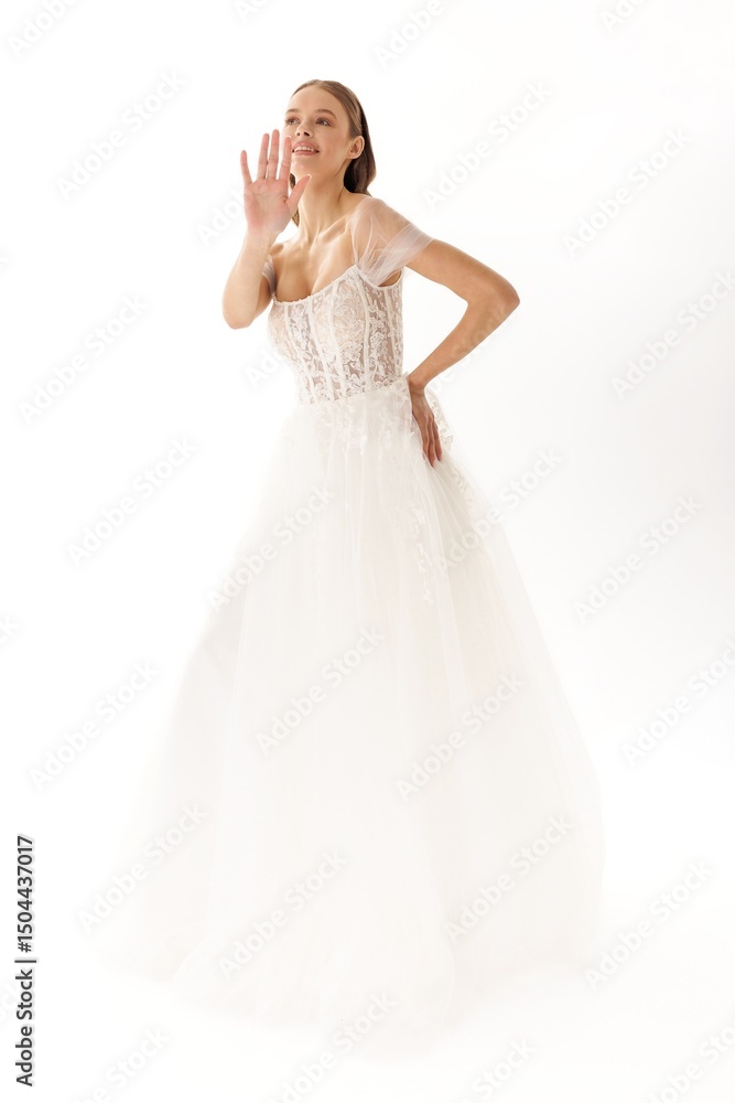 Young woman in elegant wedding dress poses gracefully against bright backdrop in indoor studio Young woman in elegant wedding dress poses gracefully against bright backdrop in indoor studio