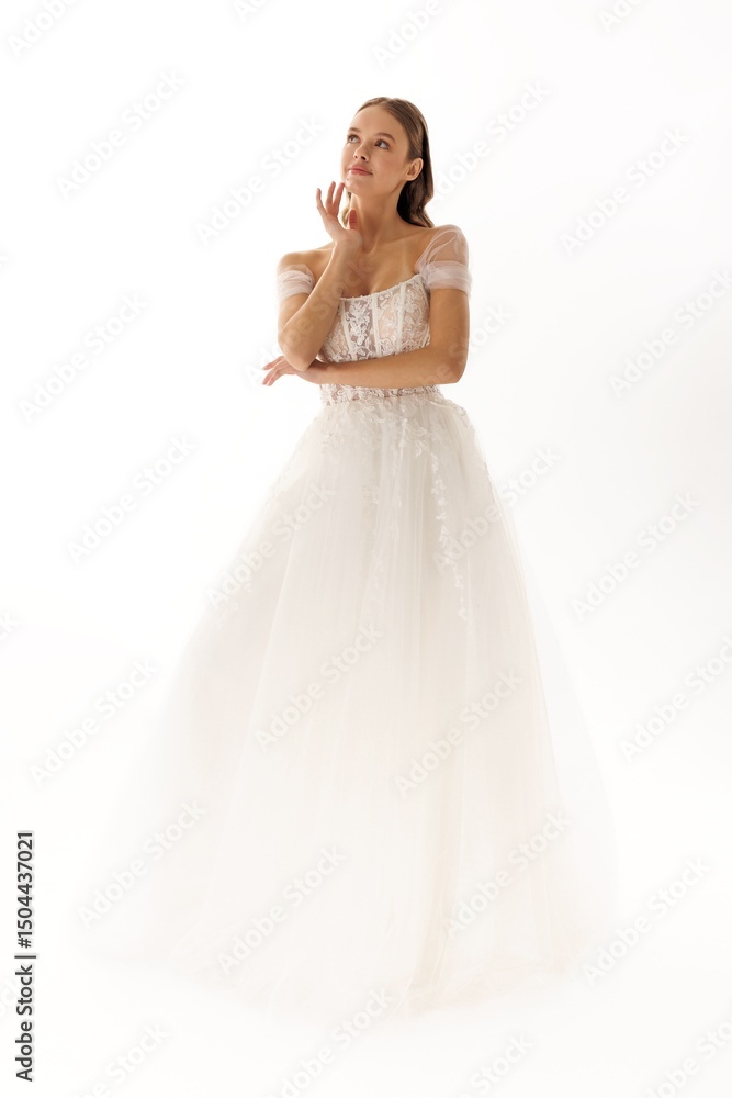 Model poses in elegant white wedding dress, showcasing bridal beauty in a soft, dreamy atmosphere during a fashion photoshoot