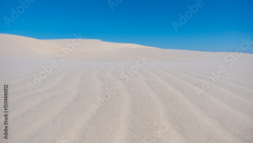Photography Endless white sand dunes under the bright blue sky in Denmarks tranquil landscap