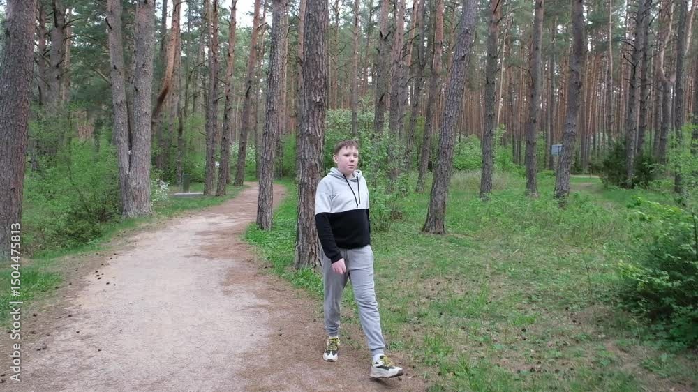 a boy walks in the forest near a lake or river a boy walks in the forest near a lake or river