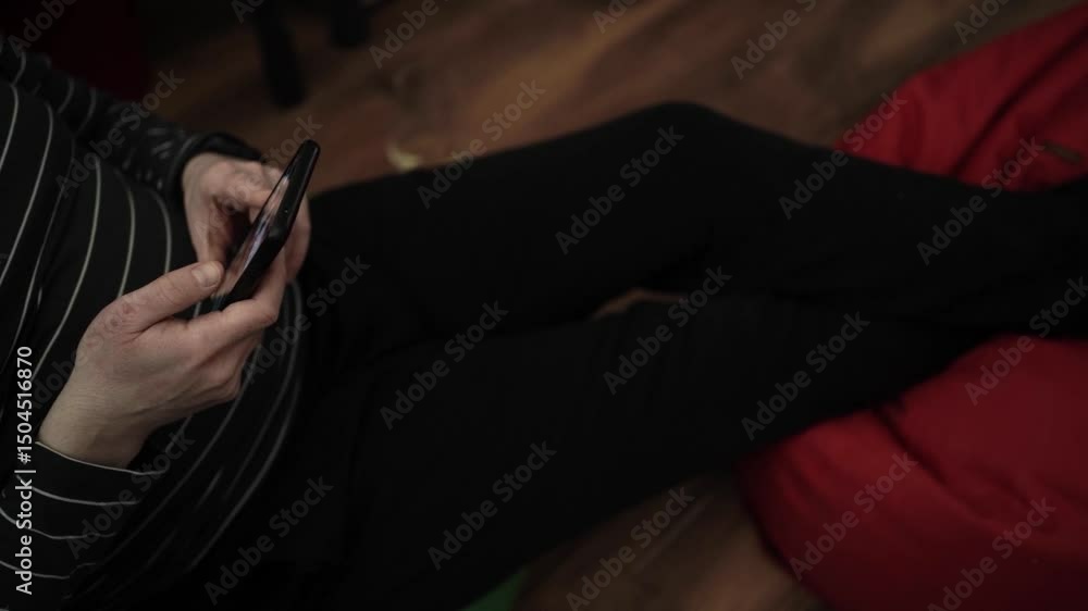 Person Scrolling Through Smartphone, Relaxed at Home — Casual Mobile Browsing and Leisure Person Scrolling Through Smartphone, Relaxed at Home — Casual Mobile Browsing and Leisure