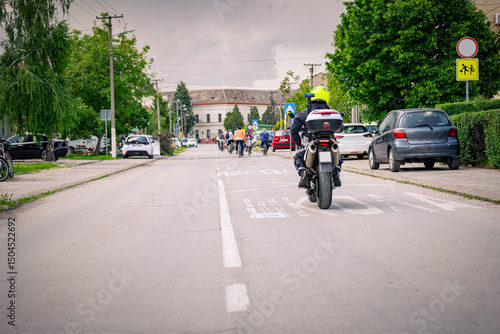 Wallpaper Mural Police officer on motorcycle secures group of cyclists on city road, street, asphalt Torontodigital.ca