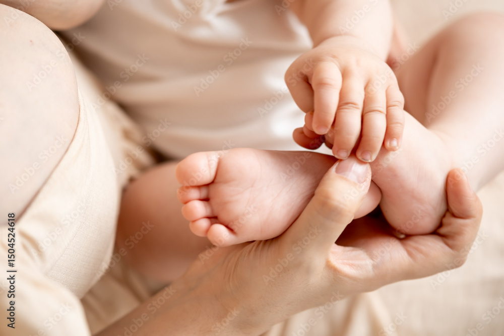 baby's feet, mother's hands hold the small feet of a newborn baby on the bed at home, maternal love and care baby's feet, mother's hands hold the small feet of a newborn baby on the bed at home, maternal love and care
