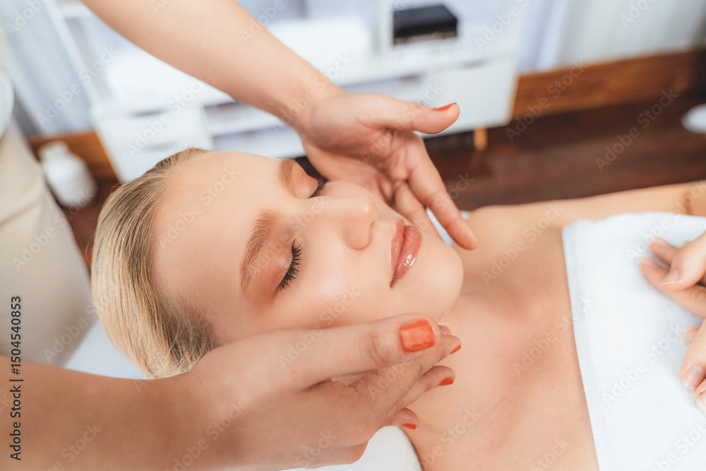 Fototapeta premium Caucasian woman enjoying relaxing anti-stress head massage and pampering facial beauty skin recreation leisure in dayspa modern light ambient at luxury resort or hotel spa salon. Quiescent