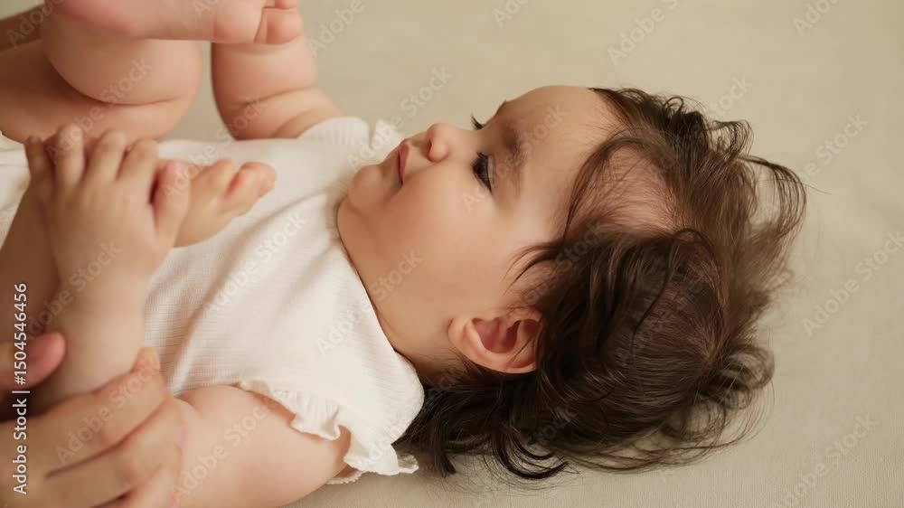 portrait of a baby in close-up, mother gently stroking the head of a newborn baby portrait of a baby in close-up, mother gently stroking the head of a newborn baby