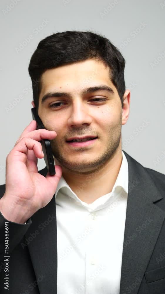 A cheerful man chats on his phone, radiating professionalism and confidence. A cheerful man chats on his phone, radiating professionalism and confidence.