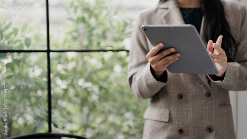 Фотография Office businesswoman using tablet to check schedules and update project progress