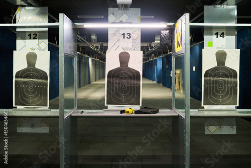 Foto Indoor shooting range featuring targets on multiple lanes for practicing shootin