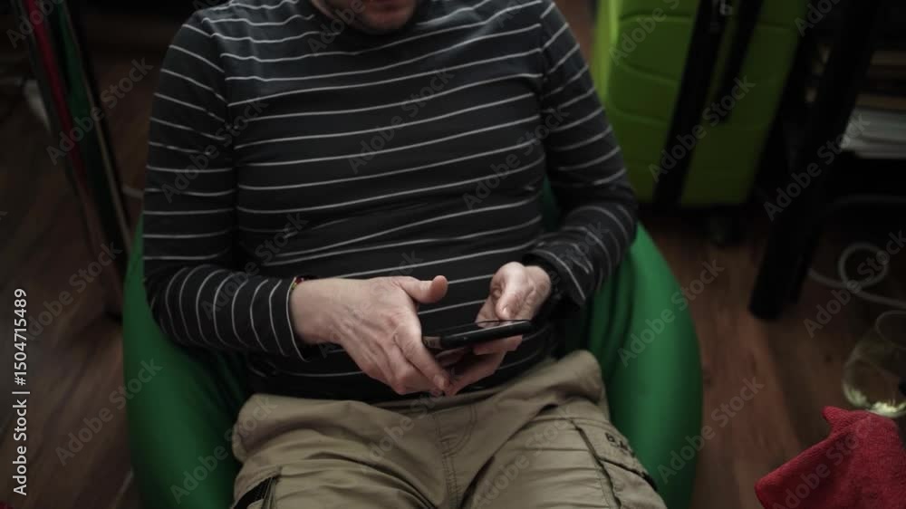 Person Scrolling Through Smartphone, Relaxed at Home — Casual Mobile Browsing and Leisure Person Scrolling Through Smartphone, Relaxed at Home — Casual Mobile Browsing and Leisure