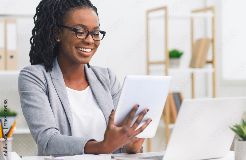 Business Applications. Black Woman Using Tablet And Laptop In Modern Office. Empty Space Business Applications. Black Woman Using Tablet And Laptop In Modern Office. Empty Space
