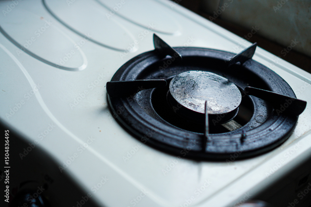 © Pernandi Imanuddin - Close-up capturing the subtle details of a gas stove burner, displaying its circular form and metallic texture, ideal for kitchen design and appliance promotional material usage.