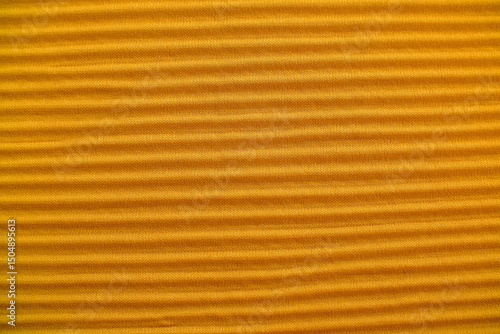 High-resolution macro photograph showcasing a rich mustard yellow fabric texture. The image captures the detailed weave of the fibers, creating a tactile, warm-toned, and high-quality textile surface.