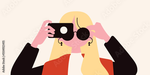 Stylish blonde woman taking a selfie with a smartphone, wearing sunglasses and trendy jacket.
